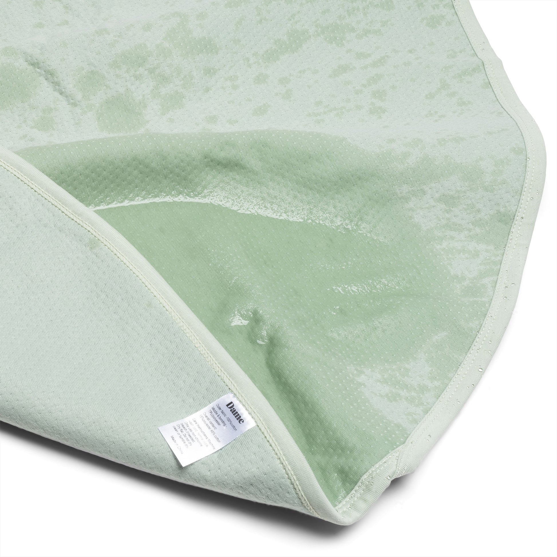 Dame sage-colored throw blanket with matching storage bag, soft and cozy accessory for home decor.