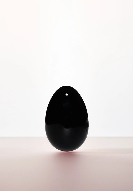 Black Obsidian yoni egg with drilled hole, from Anastasia's Bedroom Lingerie, showcasing smooth, polished gemstone for intimate wellness.