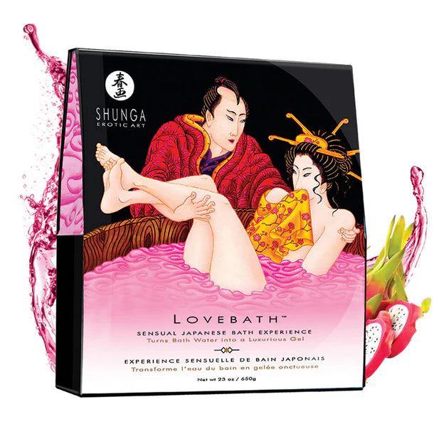 Pink sensual bath beads from Anastasia's Bedroom Lingerie displayed in a clear glass bowl on a soft fabric surface.